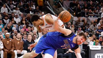 Luka Doncic #77 of the Dallas Mavericks is fouled as he drives past Victor Wembanyama #1 of the San Antonio Spurs in the second half at Frost Bank Center on March 19, 2024 in San Antonio, Texas.