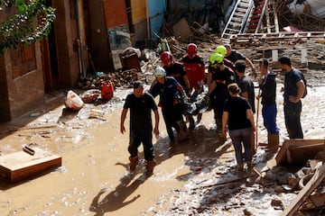 Miembros de los servicios de rescate trasladan un cuerpo sin vida tras las inundaciones en Paiporta, Valencia. 