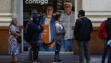 SANTIAGO, CHILE - MARCH 24: People wearing face masks queue for a bank's ATM machine during the Covid-19 pandemic on March 24, 2020 in Santiago, Chile. The "state of catastrophe" declared by president Sebastian Piñera gives the government extraordinary powers to restrict freedom of movement and assure food supply and basic services for 90 days to confront the spread of COVID-19. (Photo by Marcelo Hernandez/Getty Images)