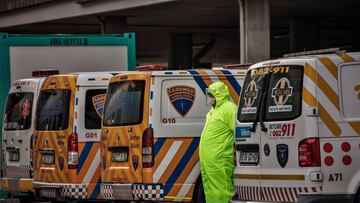 An Emergency paramedic wearing full COVID-19 coronavirus personal protective equipment (PPE) waits to have the patient he transported admitted at the Greenacres Hospital in Port Elizabeth, on July 10, 2020. - Ambulances have to queue before patients suspe