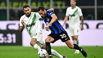Sassuolo's Albanian midfielder #11 Nedim Bajrami (L) fights for the ball with Inter Milan's Turkish midfielder #20 Hakan Calhanoglu during the Italian Serie A football match between Inter Milan and Sassuolo at the San Siro stadium in Milan on September 27, 2023. (Photo by GABRIEL BOUYS / AFP)