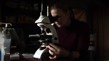 Investigadora con un microscopio.