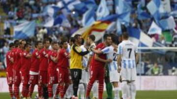 Jugadores del Málaga y el Sevilla se saludan antes del partido.