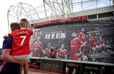 El regreso de Cristiano a la que fue su casa durante seis temporadas, doce años después, ha despertado la ilusión de los seguidores del United. En la imagen, un joven aficionado, con la camiseta del crack portugués, señala un cartel en Old Traford con varios jugadores de los Red Devils y el lema Here we belong (Aquí pertenecemos). 