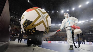 A man wearing protective gear to prevent Covid-19 (novel coronavirus) spread sprays products to disinfect the court and sidelines before the opening match of the 2021 World Men's Handball Championship between Group G teams Egypt and Chile at the Cair