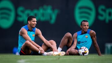 Araújo y Koundé, sentados en el césped, durante una sesión de entrenamiento del Barcelona.