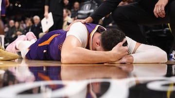 PHOENIX, ARIZONA - DECEMBER 12: Jusuf Nurkic #20 of the Phoenix Suns lays on the court after being fouled by Draymond Green (not pictured) of the Golden State Warriors during the second half of the NBA game at Footprint Center on December 12, 2023 in Phoenix, Arizona. The Suns defeated the Warriors 119-116. NOTE TO USER: User expressly acknowledges and agrees that, by downloading and or using this photograph, User is consenting to the terms and conditions of the Getty Images License Agreement.   Christian Petersen/Getty Images/AFP (Photo by Christian Petersen / GETTY IMAGES NORTH AMERICA / Getty Images via AFP)