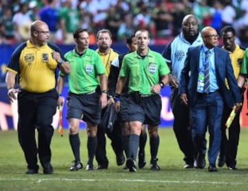 El árbitro estadounidense Mark Geiger escoltado por sus asistentes y la seguridad del estadio al concluir el partido entre Panamá y México.