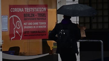 A pedestrian walks past a Covid test centre in Berlin on November 4, 2021. - Germany on November 4, 2021 saw its biggest daily rise in Covid-19 cases since the pandemic began, figures from the Robert Koch Institute (RKI) health agency showed. The country recorded 33,949 new cases in the past 24 hours, the RKI said, beating the previous daily record of 33,777 on December 18, 2020. (Photo by Tobias SCHWARZ / AFP)