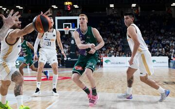 Alberto Díaz, base del Unicaja, busca un pase a un compañero cerca del aro.