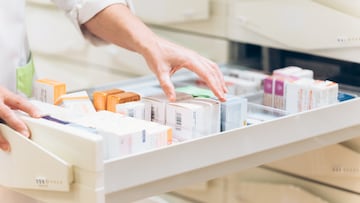 Close up of pharmacist hand taking meds from drawer
