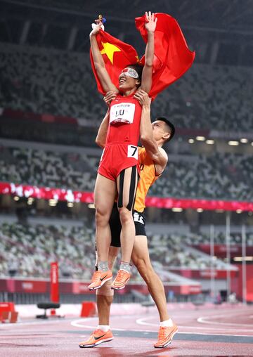 RiCuiqing Liu del equipo de China y el guía Donglin Xu celebran ganar la medalla de oro después de competir en los 200 metros femeninos