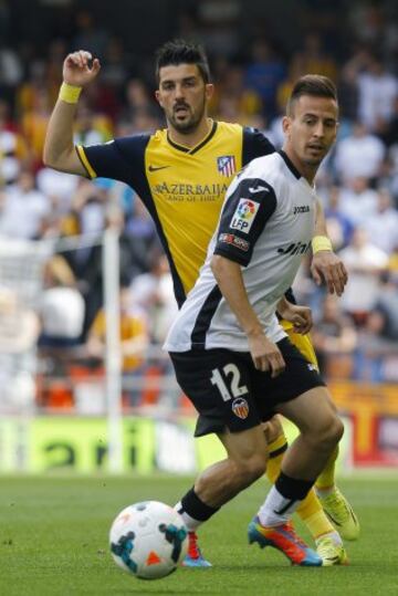 El defensa portugués del Valencia CF Joao Pereira (d), pelea un balón con el delantero del Atlético de Madrid David Villa (i) durante el partido correspondiente a la trigésima quinta jornada de la Liga BBVA, disputado esta tarde en el estadio de Mestalla. 