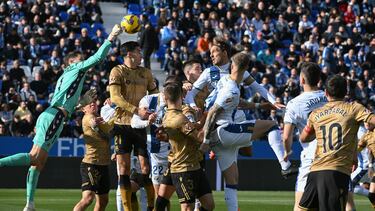LEGANÉS (MADRID), 08/12/2024.- El portero de la Real Sociedad Álex Remiro (i) despeja el balón y salvaguarda su portería ante la jugada del defensa del Leganés Sergio González (c, arriba) durante el partido de LaLiga entre el Leganés y la Real Sociedad, este domingo, en el estadio Municipal de Butarque. EFE/ Fernando Villar