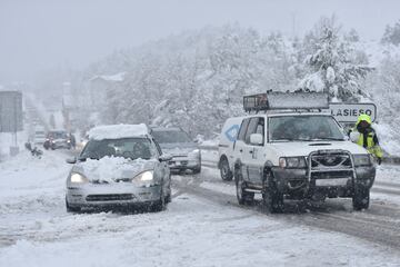 Varios coches parados en Huesca, Aragón (España). La nieve que ha empezado a caer en la madrugada ha complicado el tráfico en alrededor de una docena de carreteras del norte de la provincia de Huesca, donde las quitanieves trabajan a marchas forzadas para facilitar en lo posible el paso de los vehículos, que deben llevar cadenas o neumáticos de invierno.