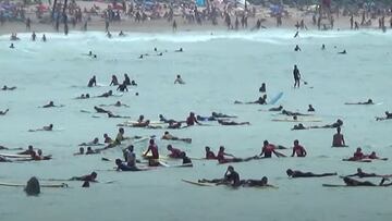 Decenas de surfistas comparten espacio en una playa de Biarritz (Francia), masificada por el surf.