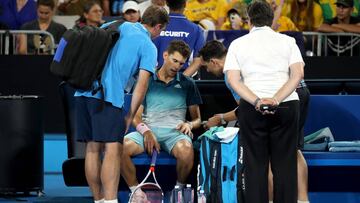 Dominic Thiem es atendido por los m&eacute;dicos y fisios durante su partido ante Alexei Popyrin en el Open de Australia.