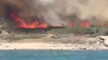 Llamas, fuego, en los arbustos de la playa de Valdevaqueros (Tarifa, C&aacute;diz), el 22 de julio del 2022. Visto desde el agua. 