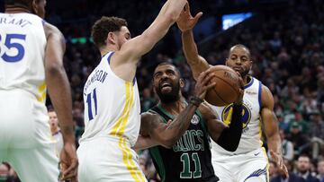 Jan 26, 2019; Boston, MA, USA; Boston Celtics guard Kyrie Irving (11) tries to find a way past Golden State Warriors guard Klay Thompson (11) and guard Andre Iguodala (right) during the second half of Golden State's 115-111 win at TD Garden. Mandatory Credit: Winslow Townson-USA TODAY Sports