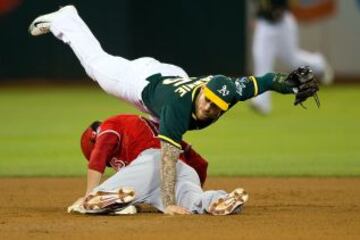 Grant Green del equipo de Los Ángeles Angels intenta ocupar la segunda base sin éxito, ya que Brett Lawrie de los Oakland Athletics atrapa la bola.