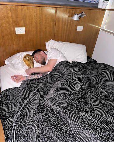Foto de Lionel Messi junto con el trofeo de la Copa Mundial de Fútbol en su dormitorio.