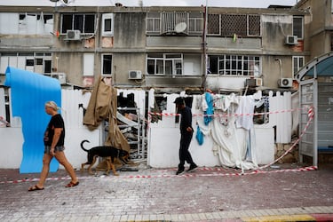 Residentes israeles caminan junto a un edificio que fue alcanzado tras los cohetes lanzados desde Gaza hacia Israel en Ashkelon.