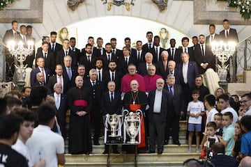 El presidente del Real Madrid, Florentino Pérez, junto al arzobispo de Madrid, Carlos Osoro, y miembros del cuerpo técnico y jugadores del equipo, posan para la foto de familia durante la ofrenda de los trofeos de LaLiga y la Liga de Campeones a la Virgen de la Almudena.
