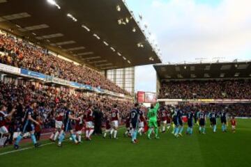 Jugadores del Burnley y del Middlesbrough salen al terreno de juego con el estadio del Burnley, Turf Moor, a rebosar.