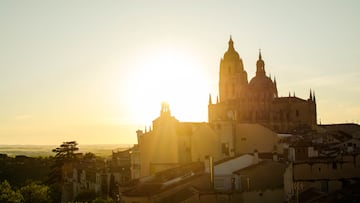 Segovia cathedral stands tall against a golden sunrise, casting a majestic glow over the cityscape
