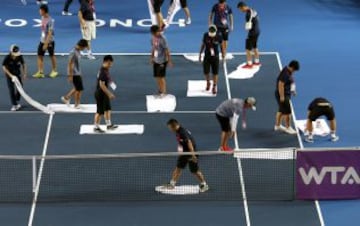 Los asistentes secando la pista durante el Open de Hong Kong.