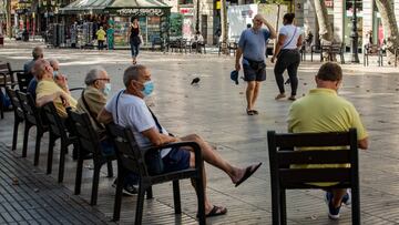 Imagen de las Ramblas de Barcelona, donde varios hombres se encuentran sentados en varias sillas dispuestas en la calle.