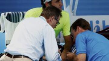 Roger Federer es atentido por los médicos durante el partido.