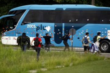 La policía intenta proteger el autobús en el que viajan los jugadores de la selección brasileña de fútbol durante una protesta de maestros de Río de Janeiro.