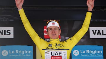 UAE Team Emirates XRG's Slovenian rider Tadej Poga?ar wearing the overall leader's yellow jersey celebrates winning the overall race on the podium of the 8th and final stage of the 77th edition of the Criterium du Dauphine cycling race, 133,3 km between Val-d'Arc and Val-Cenis - Plateau du Mont Cenis, on June 15, 2025. (Photo by Anne-Christine POUJOULAT / AFP)