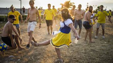 Esta seguidora sueca, vestida con un típico traje del país, chuta un balón y parece que va a ser gol.