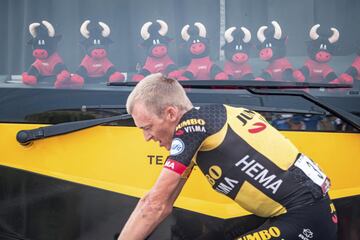 Robert Gesink pasa por delante del autobús de su equipo ante la mirada cómplice de la mascota de la Vuelta a España, el toro Tei-Tei, que se multiplica en el seno de la escuadra Jumbo-Visma gracias a la poderosa participación de su líder, Primoz Roglic, actual maillot rojo de la carrera y vencedor de tres etapas.