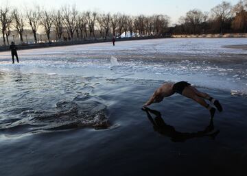 Un nadador de hielo se zambulle en un lago parcialmente congelado en Shenyang, en la provincia nororiental china de Liaoning. En esta región se cree que la natación en invierno mejora la circulación y beneficia la salud. 