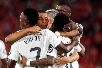 Real Madrid's Brazilian forward #11 Rodrygo (R) celebrates scoring his team's first goal with teammates during the Spanish league football match between RCD Mallorca and Real Madrid CF at the Mallorca Son Moix stadium in Palma de Mallorca on August 18, 2024. (Photo by JAIME REINA / AFP)