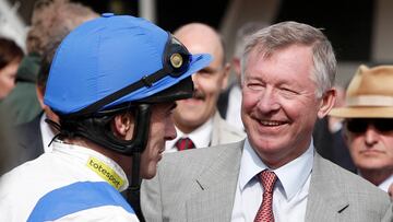 El exentrenador del Manchester United Sir Alex Ferguson saluda a un jockey durante la celebración del Grand National de 2010.