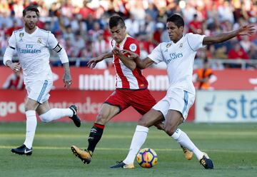 El centrocampista del Girona Pere Pons  disputa un balón con los defensas del Real Madrid Sergio Ramos y Raphael Varane