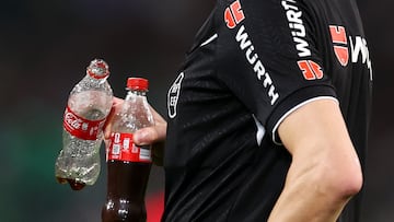 El árbitro Ricardo De Burgos recoge las botellas lanzadas al terreno de juego tras el segundo gol del Sevilla.