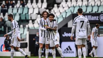 Juventus' American midfielder Weston McKennie (C) celebrates with Juventus' French midfielder Adrien Rabiot (l) and Juventus' Portuguese forward Cristiano Ronaldo (R) after scoring Juventus' third goal during the Italian Serie A footba