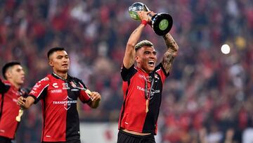 Luis Reyes corre con el trofeo de campe&oacute;n por el estadio