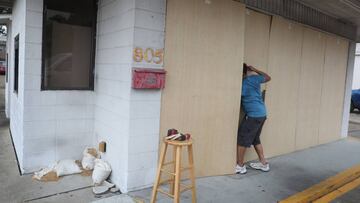 LAKE CHARLES, LOUISIANA- AUGUST 25: Da Kim works on placing plywood over the windows of a donut shop before the possible arrival of Hurricane Laura on August 25, 2020 in Lake Charles, Louisiana. Hurricane Laura is expected to hit somewhere along the Gulf 