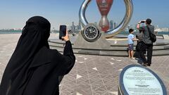 Soccer Football - Qatar to stage 2023 Asian Cup after the World Cup - Doha, Qatar - October 17, 2022 A woman takes a photograph of the FIFA World Cup Qatar 2022 countdown clock after Qatar was confirmed as the host nation of the 2023 AFC Asian Cup REUTERS/Hamad I Mohammed
