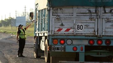 A police officer asks a truck driver for a special permission to drive, as towns that are near the Rosario grains export hub have been blocked for ground transportation as Argentina locks down against the coronavirus (COVID-19) disease, in Ibarlucea, Santa Fe, Argentina March 28, 2020. Picture taken March 28, 2020. REUTERS/Stringer NO RESALES. NO ARCHIVES