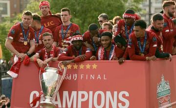 Liverpool's English midfielder Jordan Henderson and Liverpool's Belgian striker Divock Origi hold the European Champion Clubs' Cup trophy during an open-top bus parade around Liverpool