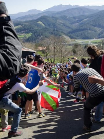 Varios ciclistas se abren paso entre la gente hoy en el Alto de La Antigua, en la localidad guipuzcoana de Zumarraga, durante la tercera etapa de la 55 edición de la Vuelta al País Vasco.