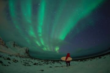 Este surfista está una playa nevada de una isla de Lofoten, en el Ártico, viendo una Aurora Boreal, aunque  la sensación es de estar dentro de la película ‘Buscando a Nemo’, a punto de coger la gran corriente marina de Australia Oriental con su tabla.