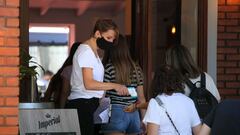 La trabajadora de un restaurante de Buenos Aires, toma la temperatura a sus clientes antes de su ingreso al establecimiento.